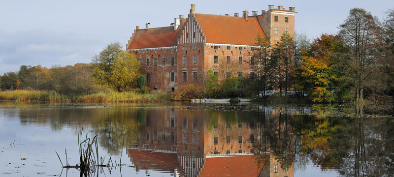 Svaneholm Castle in front of the lake on an autumn day